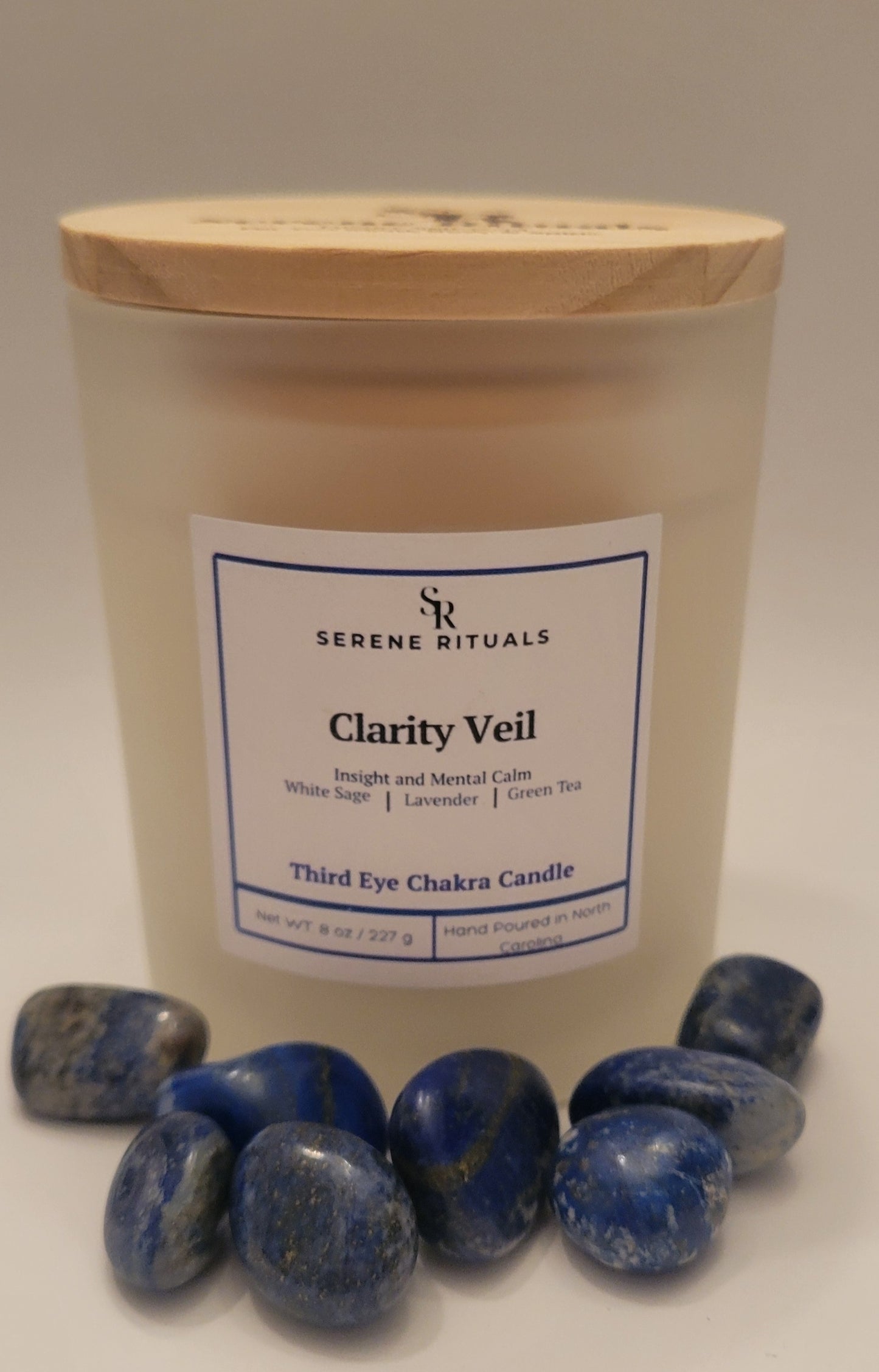Candle labeled 'Clarity Veil' from Serene Rituals with Lapis Lazuli stones on a white background