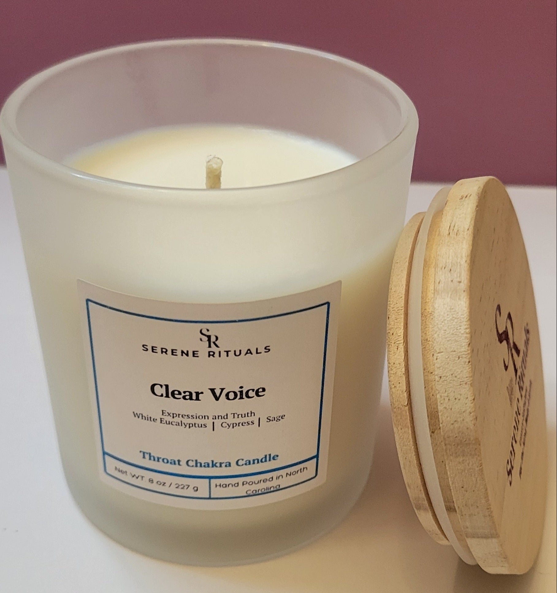 Scented candle with wooden lid labeled 'Clear Voice' by Serene Rituals on a white surface.