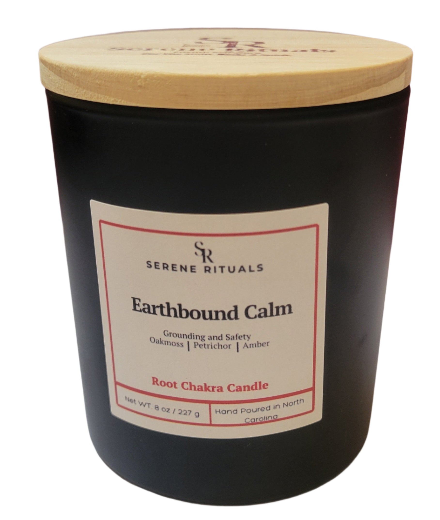 Black candle with a wooden lid labeled 'Earthbound Calm' by Serene Rituals on a white surface.