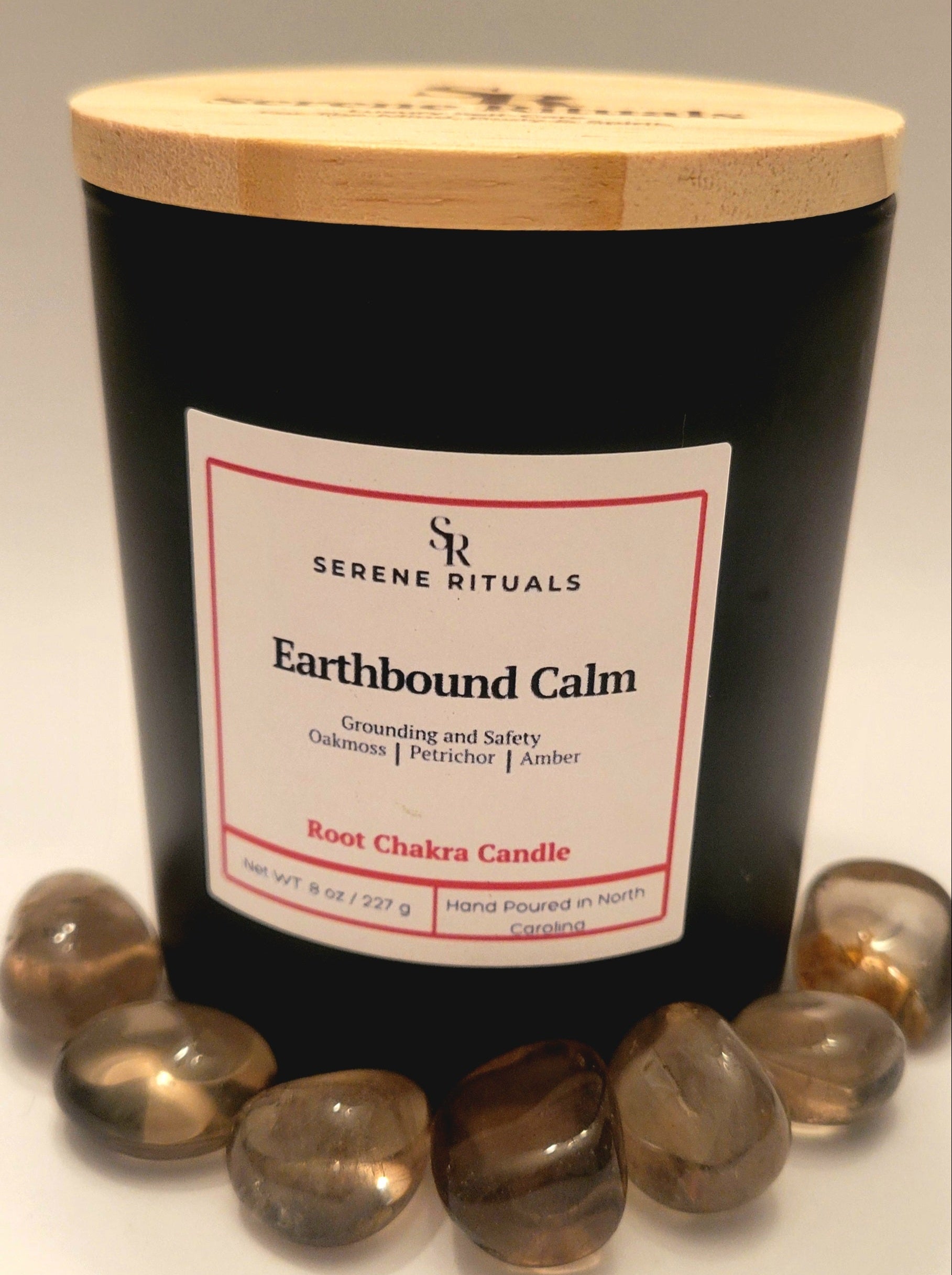 Earthbound Calm candle with wooden lid and 'Serene Rituals' label on a white background