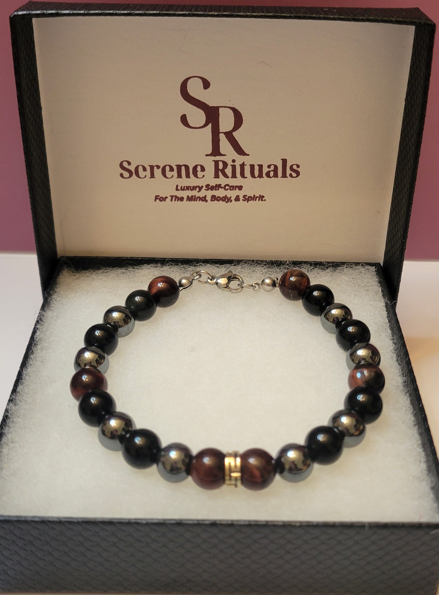 Midnight Armor gemstone  bracelet with black Obsidian, Red Tiger's Eye, and Hematite gemstone beads on display in a 'Serene Rituals' branded box.