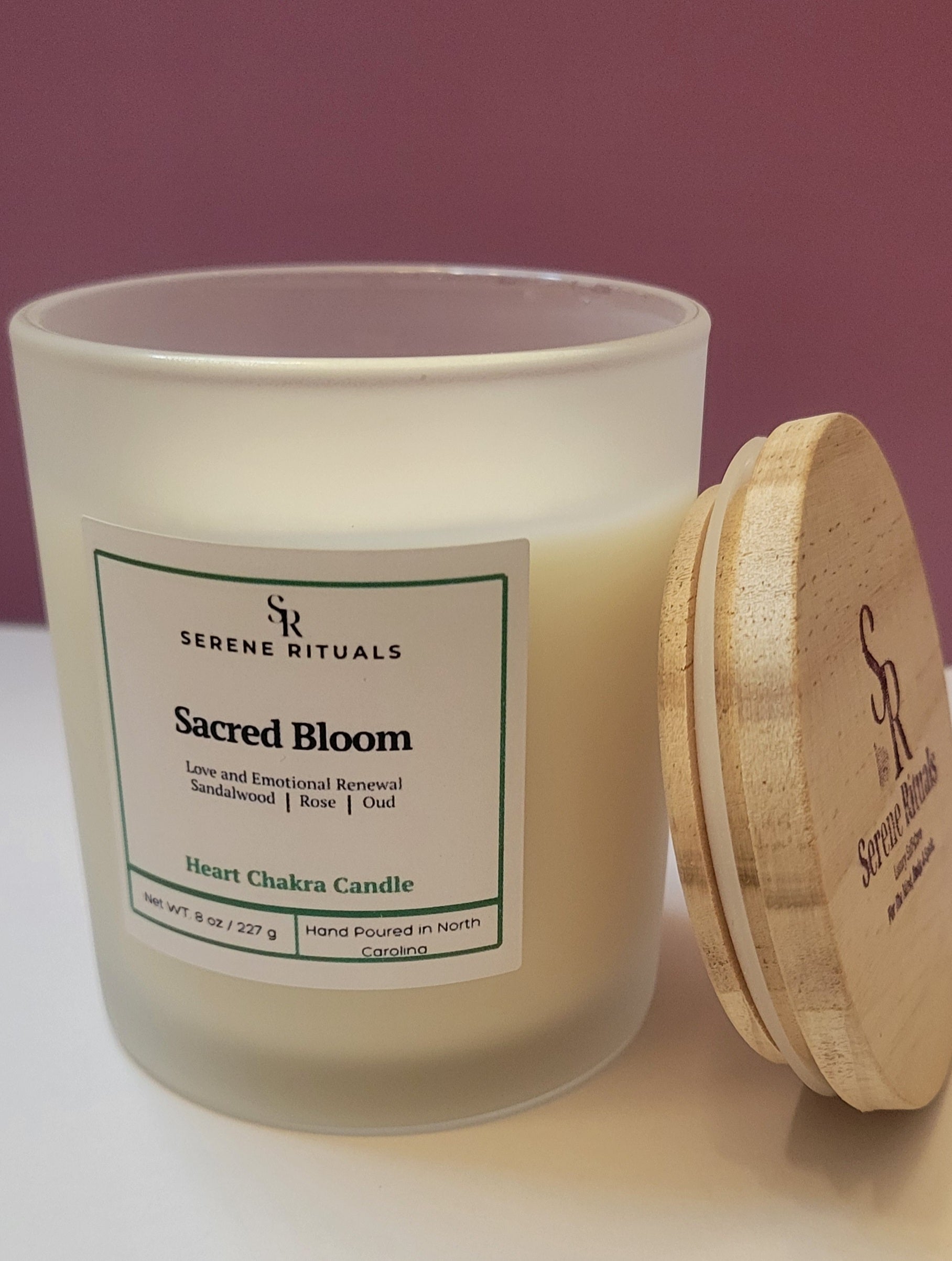 Serene Rituals Sacred Bloom candle with wooden lid on a white surface against a purple background