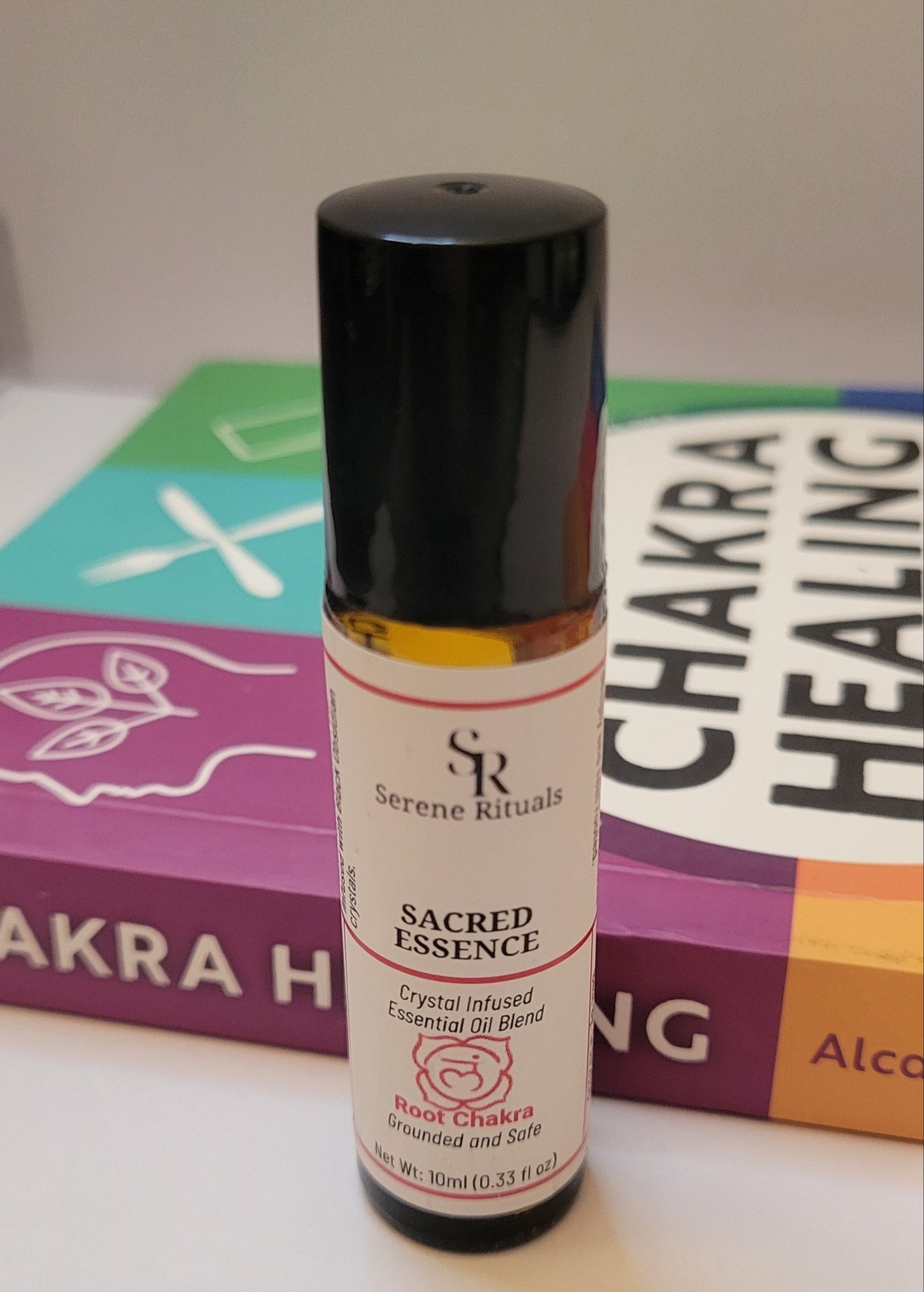 Serene Rituals Sacred Essence bottle on a white surface with a blurred background