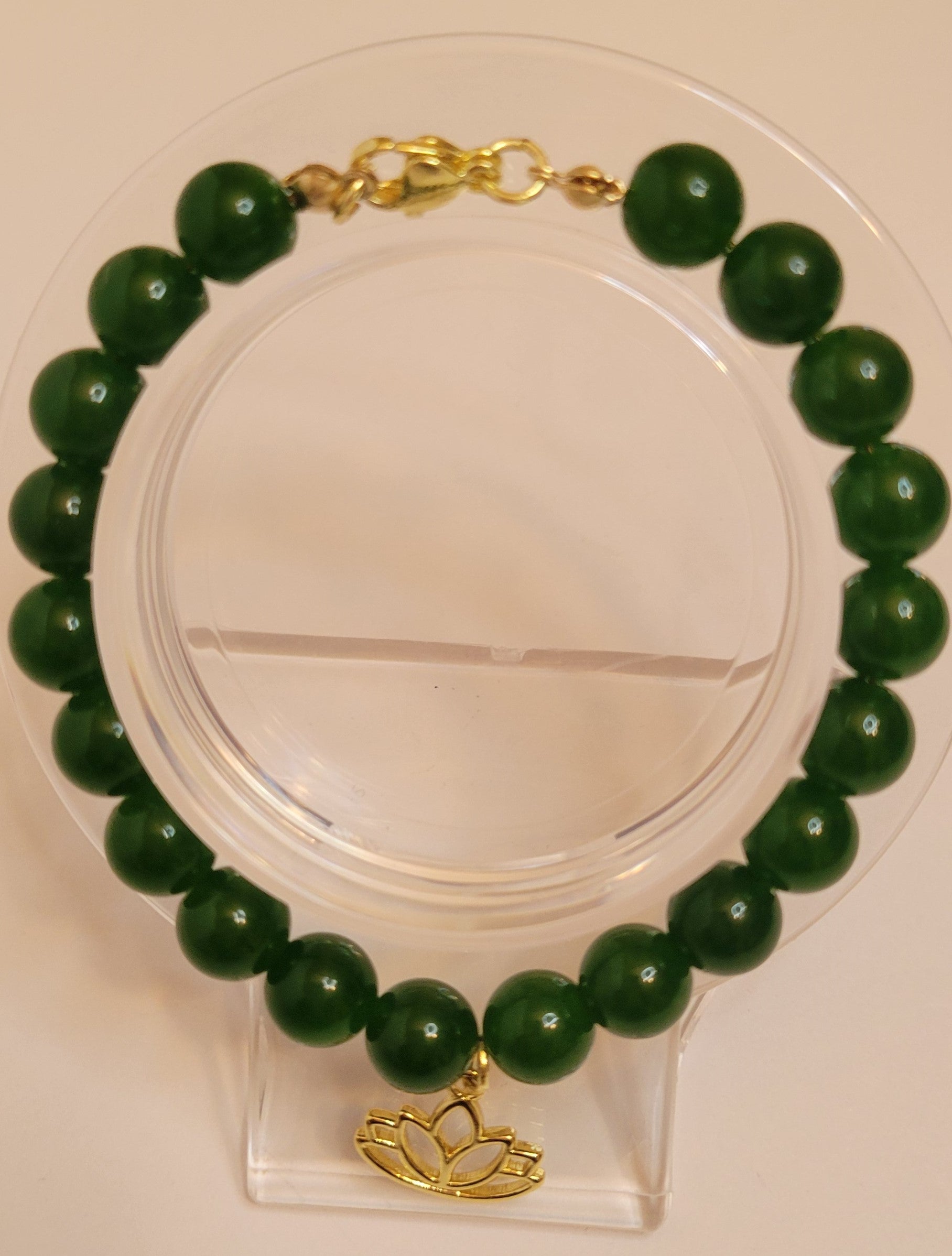 A handcrafted bracelet featuring polished Taiwan Green Nephrite Jade beads, gold-filled lotus charm and clasp. The design embodies balance, harmony, and grounding energy, styled as part of Serene Rituals’ luxury gemstone collection.