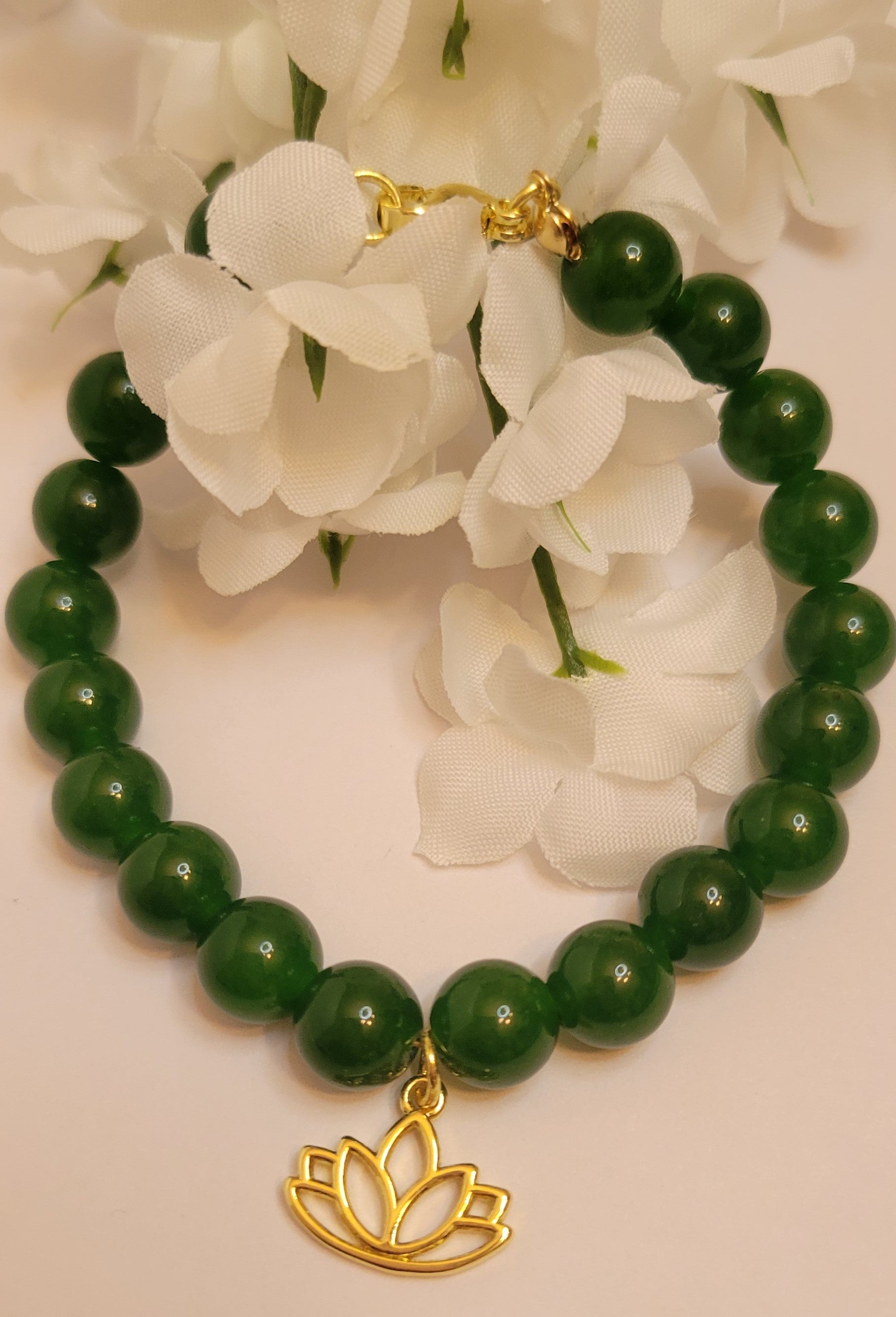 A handcrafted bracelet featuring polished Taiwan Green Nephrite Jade beads, gold-filled lotus charm and clasp. The design embodies balance, harmony, and grounding energy, styled as part of Serene Rituals’ luxury gemstone collection.