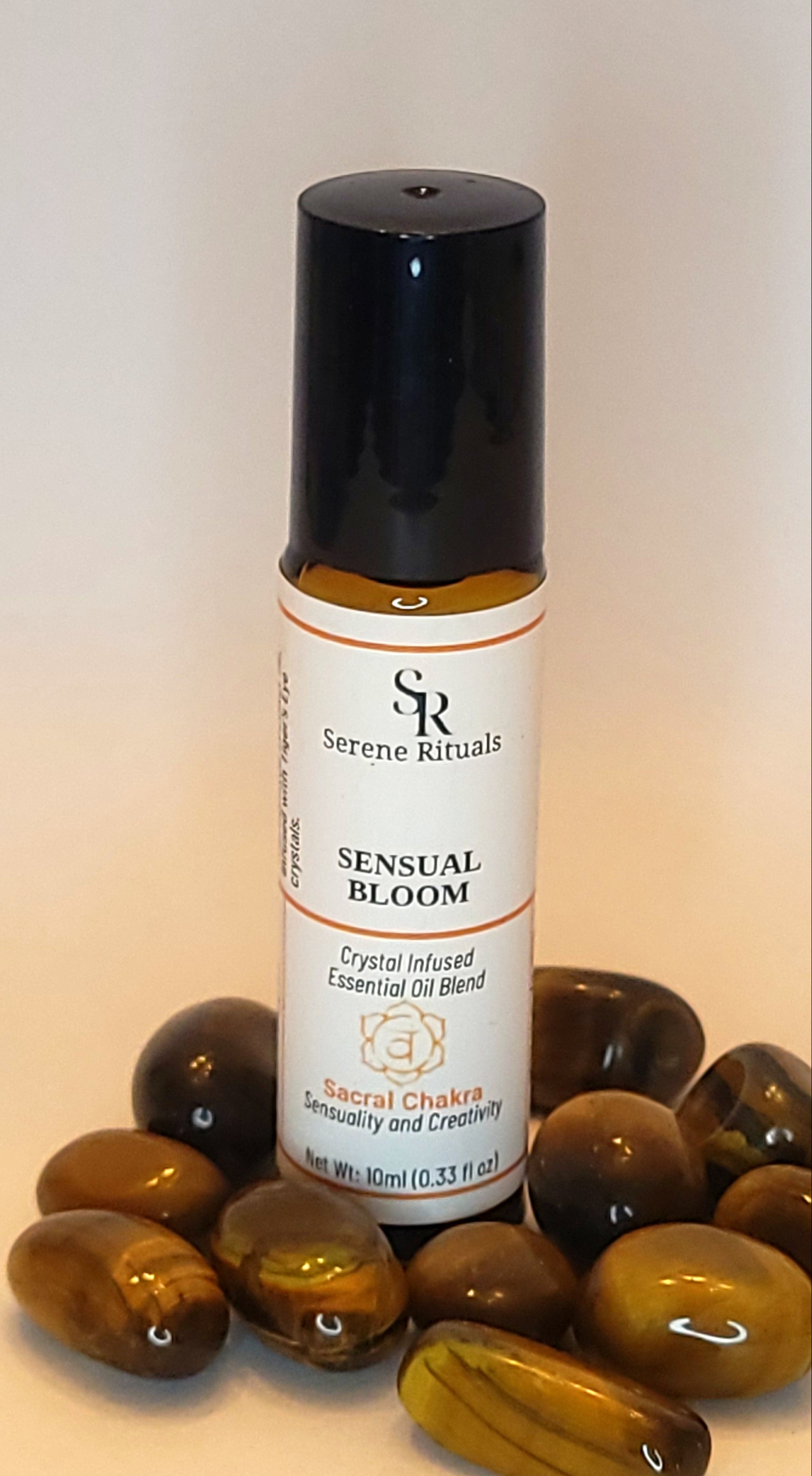 Small bottle labeled 'Sense of Bloom' with amber glass stones on a light background