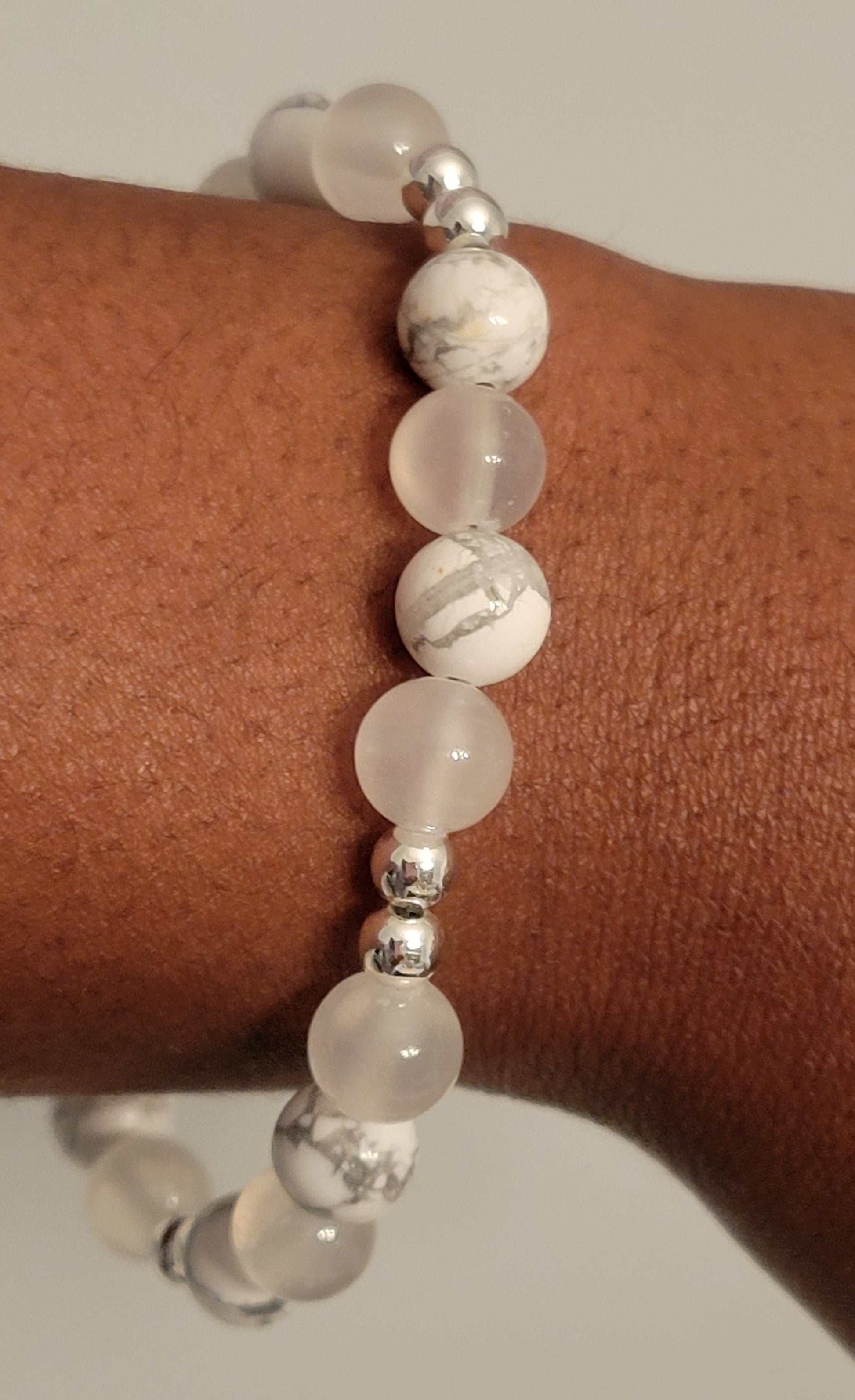 Serenity Glow Bracelet with Howlite and Selenite  beads and silver accents on a wrist against a neutral background