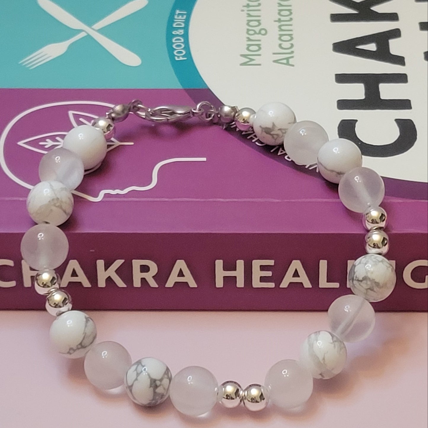 Serenity Glow Bracelet with Howlite and Selenite  beads on a book titled 'Chakra Healing'