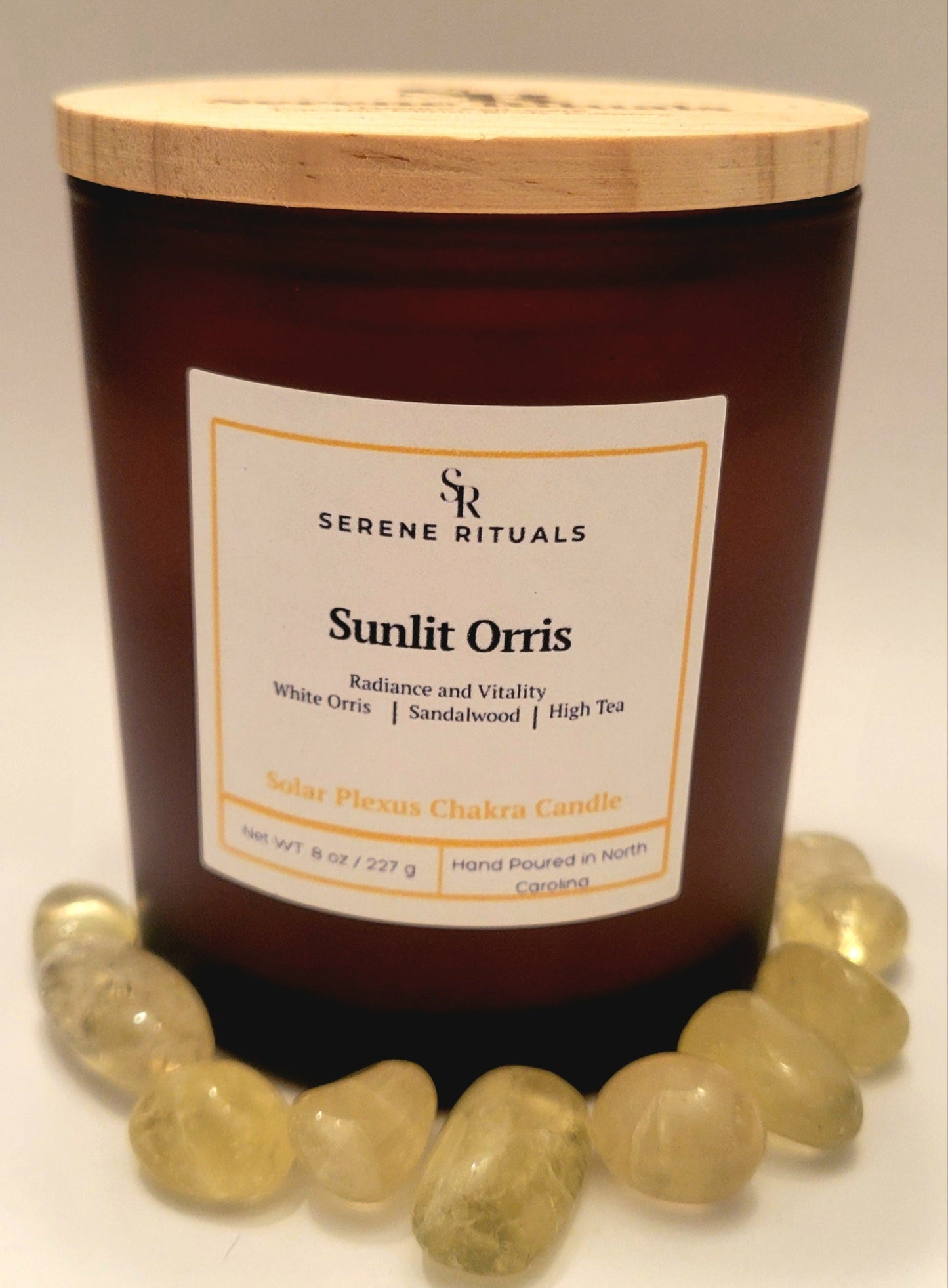 Candle labeled 'Sunlit Orris' by Serene Rituals with a wooden lid on a neutral background.