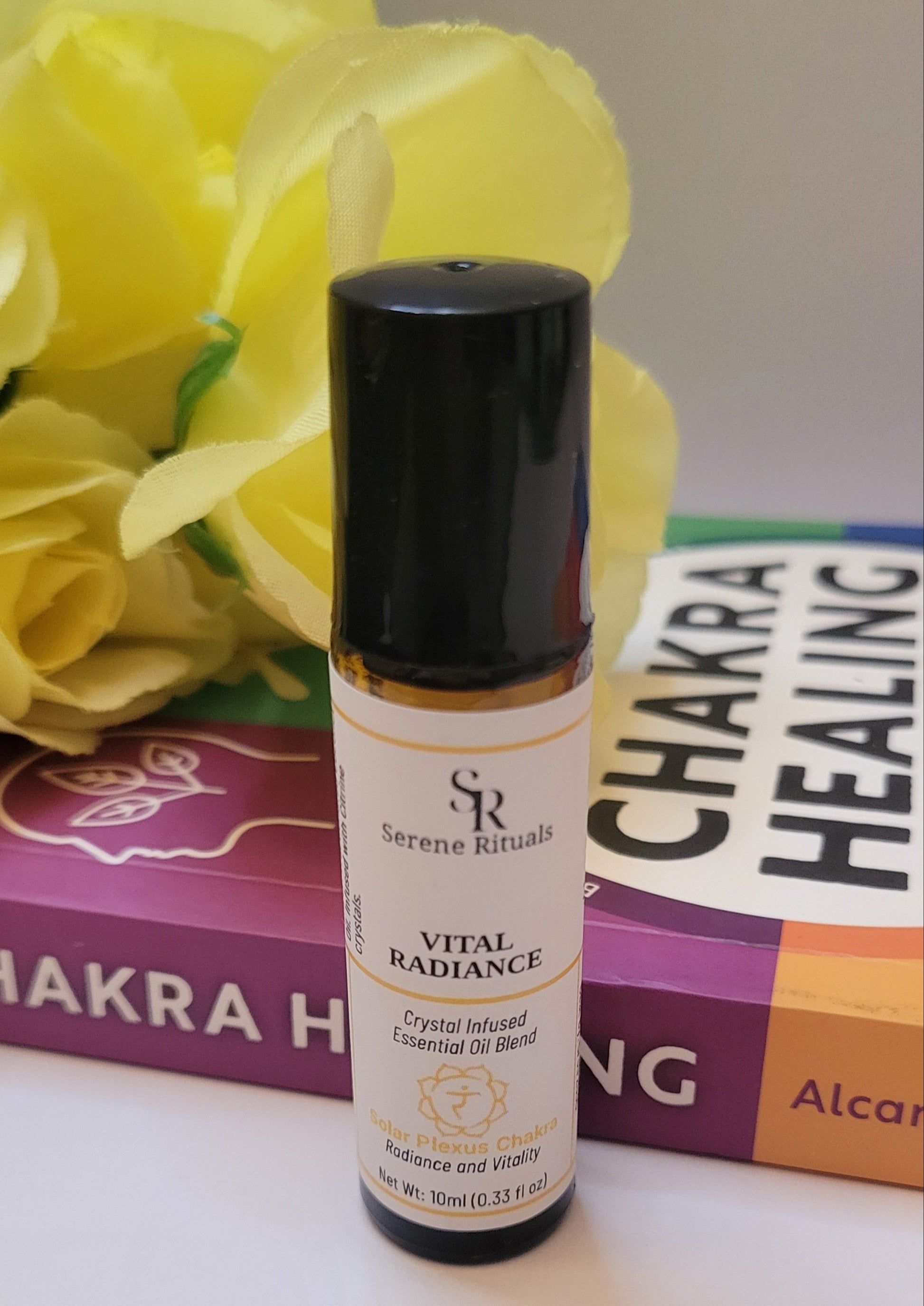Serene Rituals Vital Radiance bottle with yellow flowers and books in the background